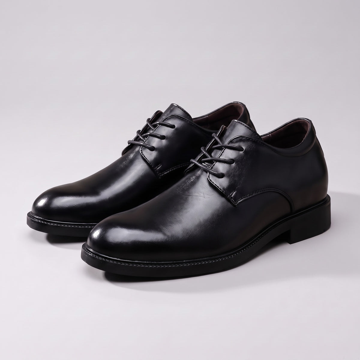 A pair of The Summit black leather derby shoes on a pale grey studio background