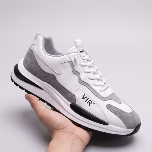 Vintage in Rwanda sneaker in white and grey, held in one hand